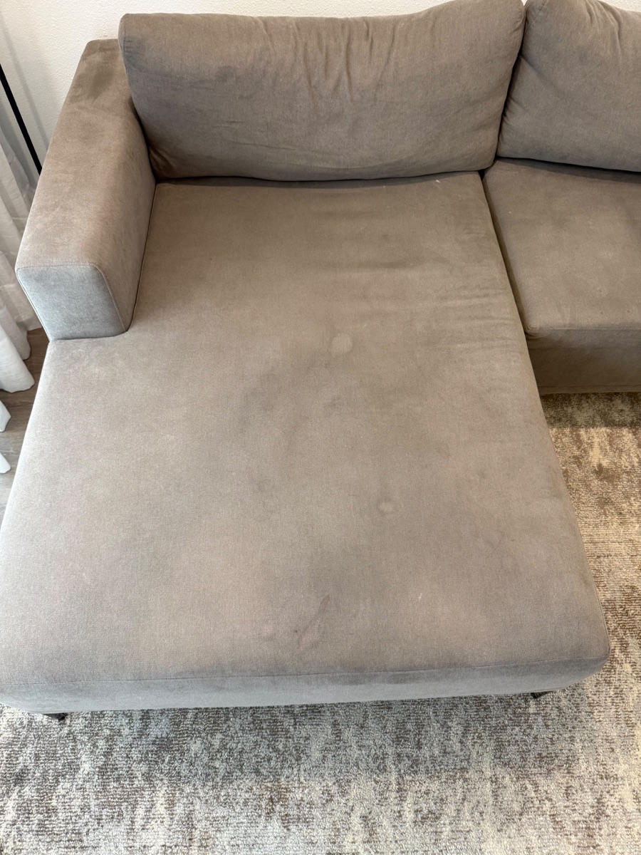 Sectional sofa with stains and marks before cleaning